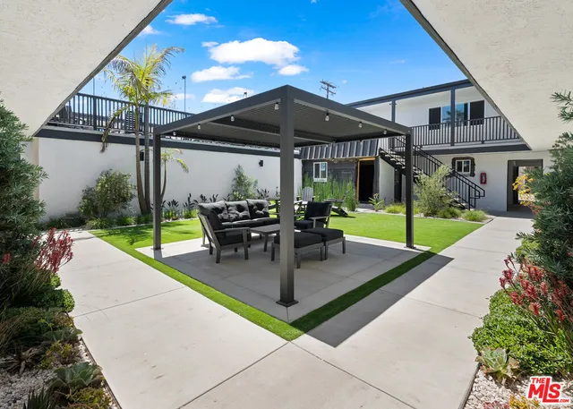 a view of a patio with a table and chairs under an umbrella