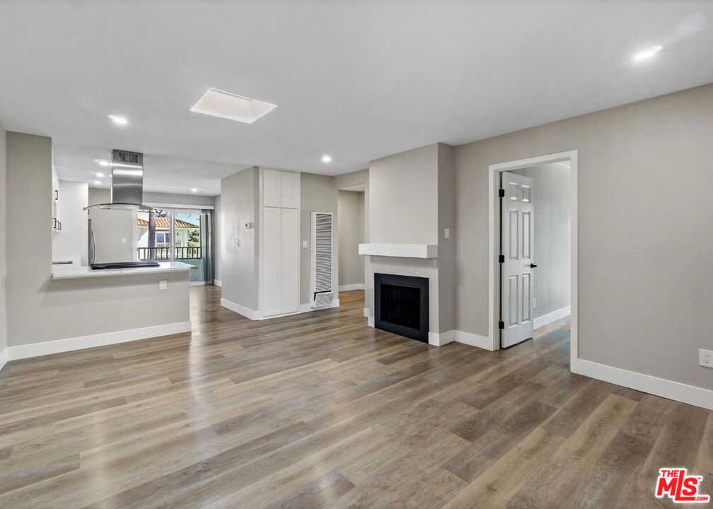 125 16th Street Huntington Beach, CA 92648 - Photo 9 of 10 a view of empty room with wooden floor and fireplace