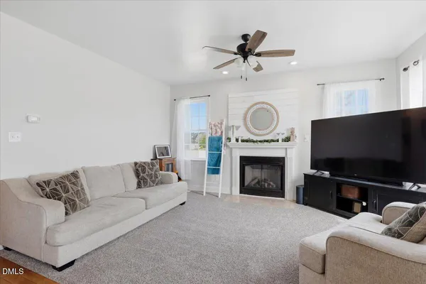 a living room with furniture a fireplace and a flat screen tv