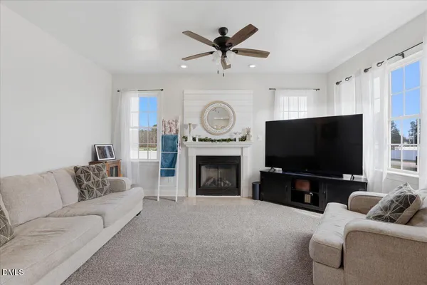 a living room with furniture a fireplace and a flat screen tv