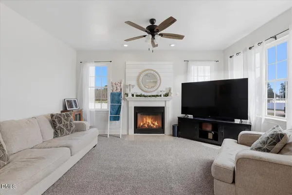 a living room with furniture a fireplace and a flat screen tv