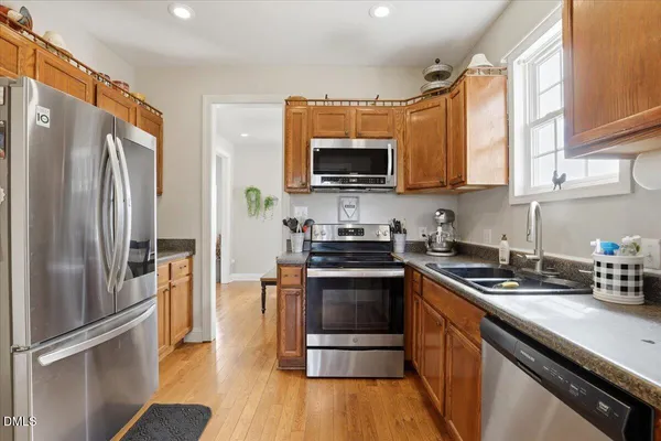 a kitchen with stainless steel appliances a refrigerator sink and microwave