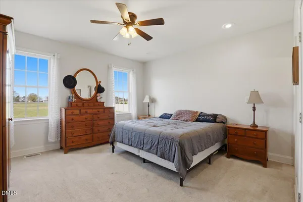 a bedroom with a bed a dresser and a chandelier