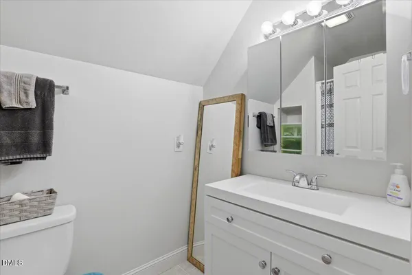 a bathroom with a sink a light fixture and a toilet