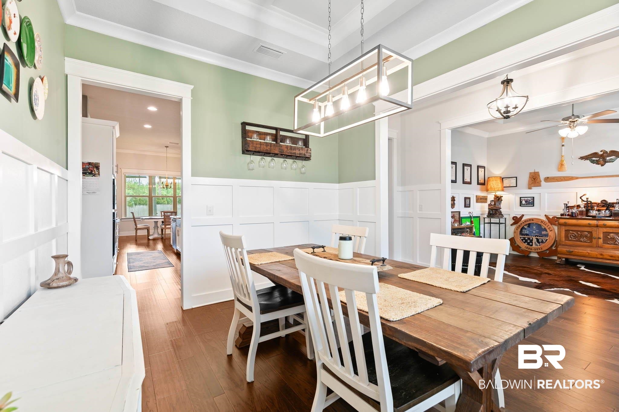 12785 Warbler Street Daphne, AL 36527 - Photo 28 of 53 Dining area featuring a decorative wall, hardwood / wood-style floors, ornamental molding, a ceiling fan, and wainscoting