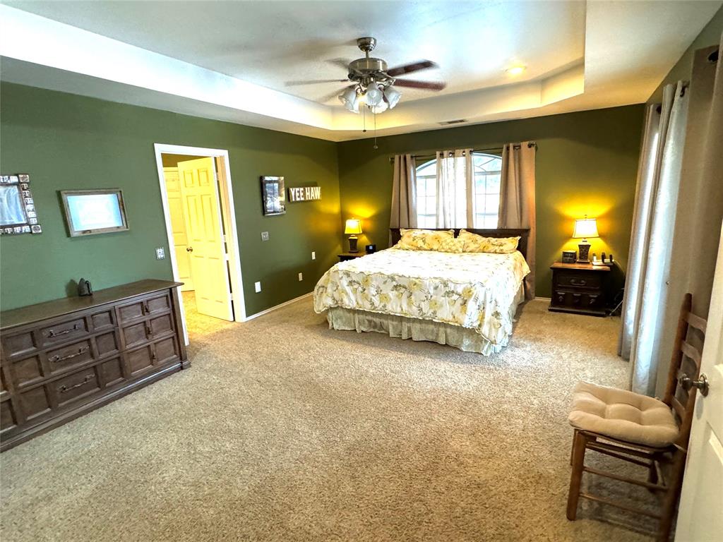 505 3rd Street Dodd City, TX 75438 - Photo 18 of 37 a spacious bedroom with a bed and a couch
