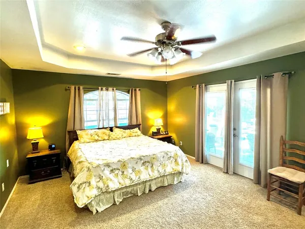 a living room with furniture and a flat screen tv with kitchen view