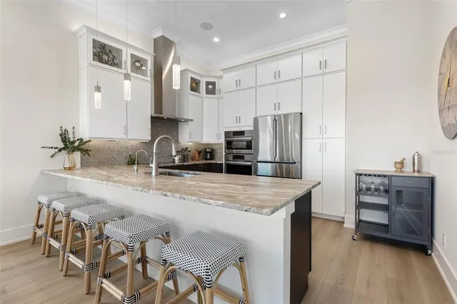 a kitchen with granite countertop a refrigerator a stove and a sink
