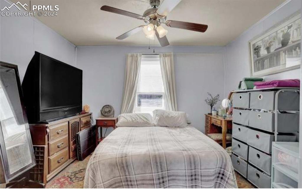 24119 Eccles Street Elbert, CO 80106 - Photo 16 of 23 a bedroom with a bed and a flat tv screen on dresser