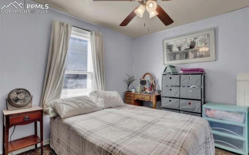 24119 Eccles Street Elbert, CO 80106 - Photo 17 of 23 a bedroom with a bed and a chandelier