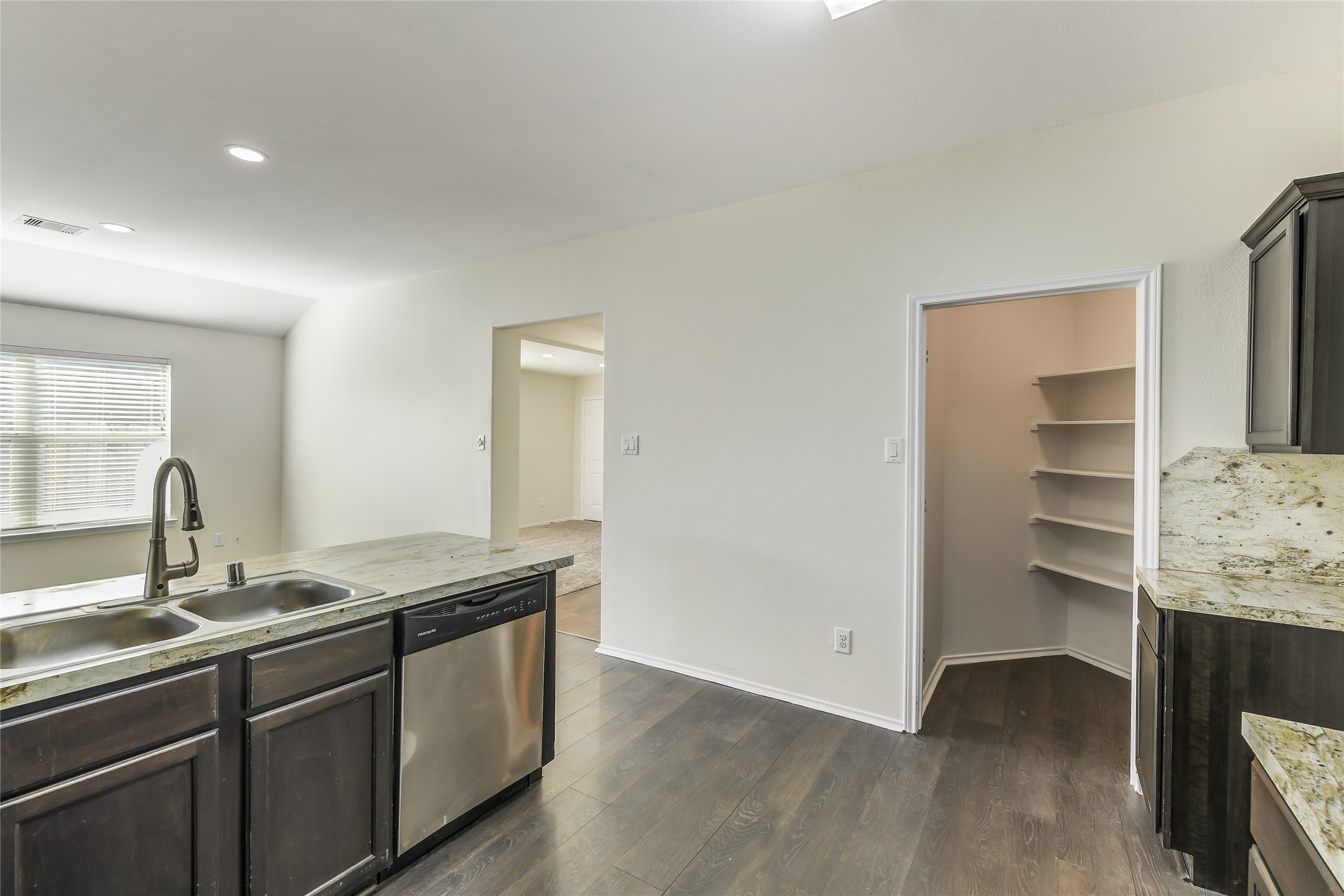 2023 Louetta Mist Drive Spring, TX 77388 - Photo 15 of 39 a kitchen with granite countertop a sink and a wooden floor