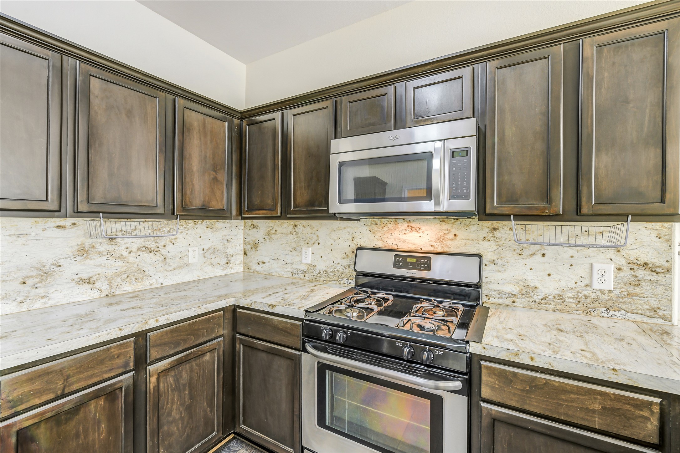2023 Louetta Mist Drive Spring, TX 77388 - Photo 16 of 39 a kitchen with granite countertop cabinets stainless steel appliances and wooden cabinets