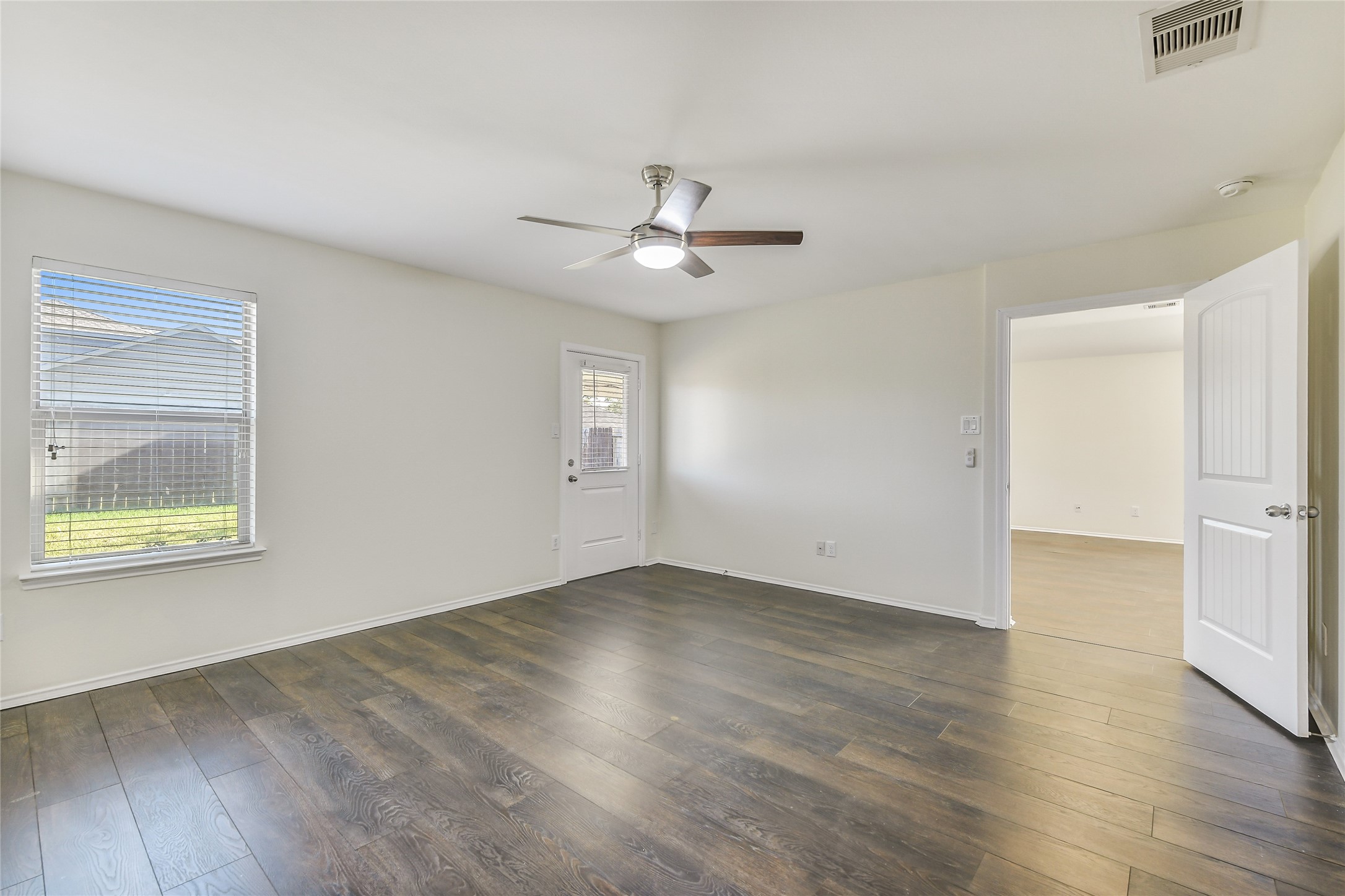 2023 Louetta Mist Drive Spring, TX 77388 - Photo 28 of 39 an empty room with wooden floor chandelier fan and windows