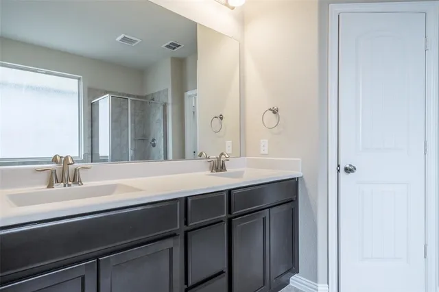 a bathroom with a double vanity sink and a mirror