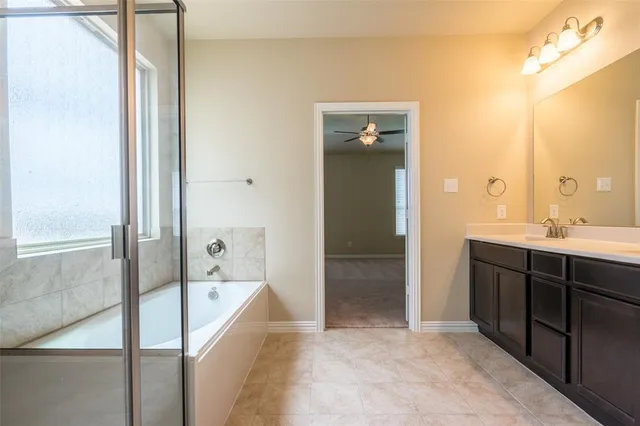 a spacious bathroom with a bathtub sink and mirror