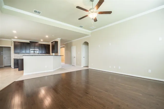 a view of a big room with wooden floor and a ceiling fan
