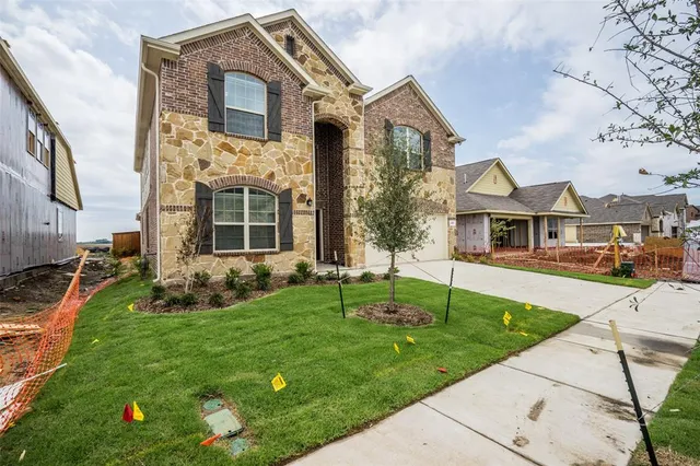 a front view of a house with a yard and trees