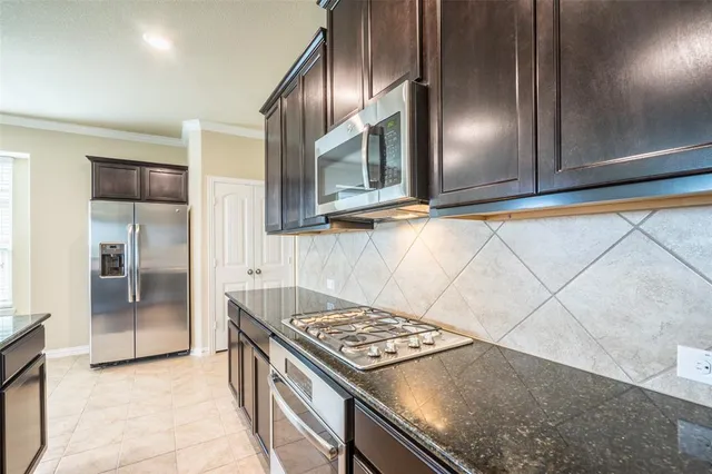 a kitchen with granite countertop a stove and a refrigerator