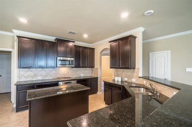a kitchen with stainless steel appliances granite countertop a sink and a stove