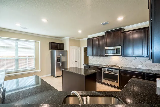 a kitchen with stainless steel appliances granite countertop a stove and a sink