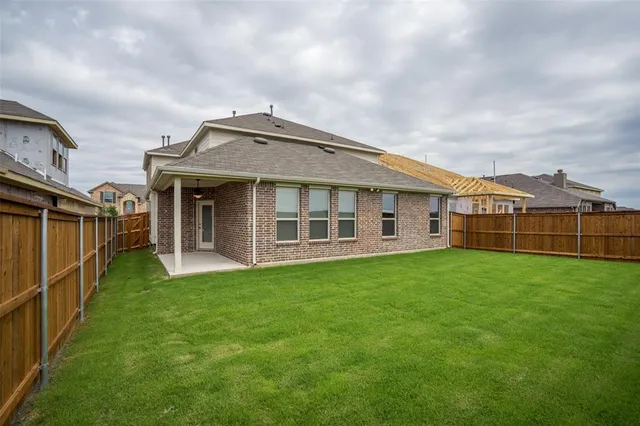 a view of a big house with a big yard and large trees