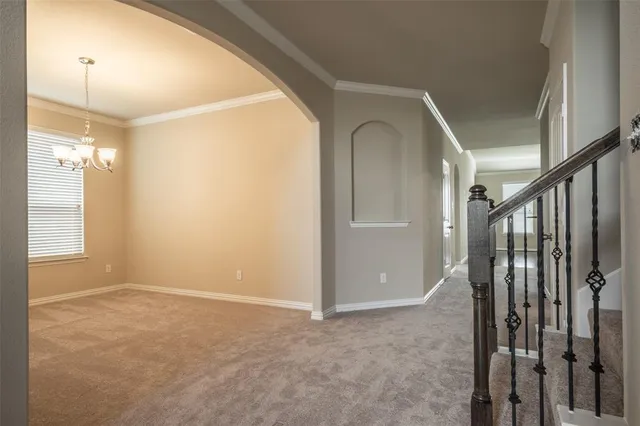 a view of hallway with stairs and a window