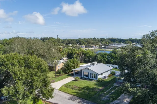 an aerial view of a house with yard and mountain view in back