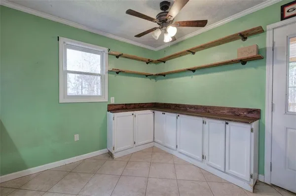 an empty room with ceiling fan and window