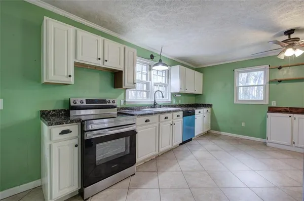 a kitchen with granite countertop a stove sink and cabinets
