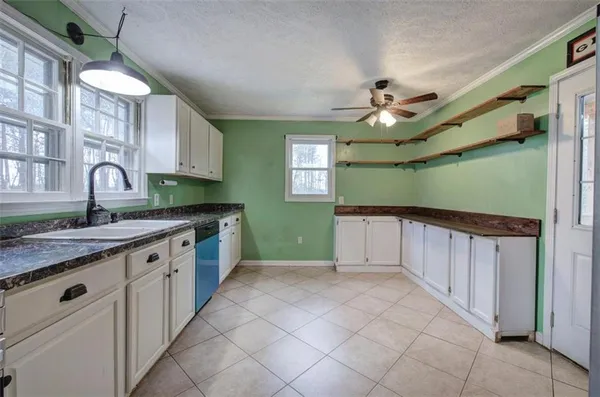 a kitchen with kitchen island granite countertop a sink window and cabinets
