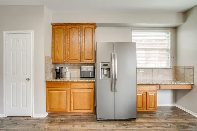 a kitchen with a table chairs refrigerator and cabinets