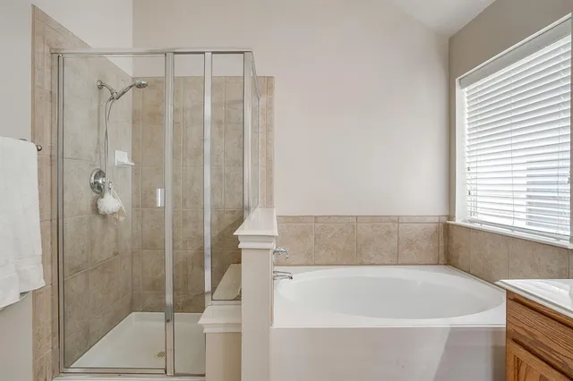 a bathroom with a tub sink and mirror