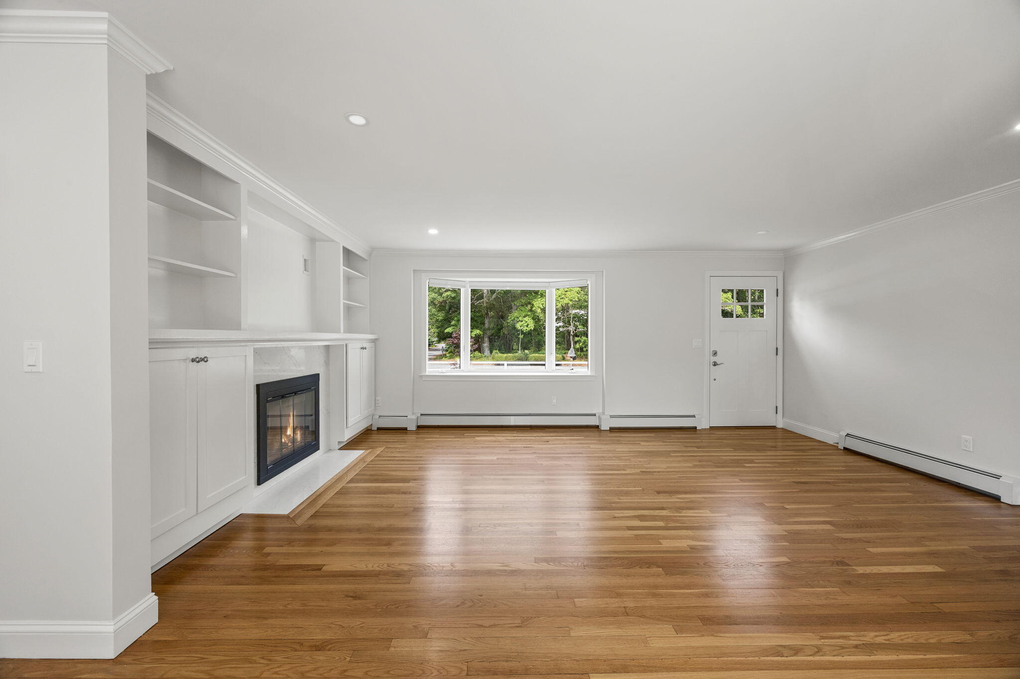 28 Vandermint Lane Hyannis, MA 02601 - Photo 11 of 47 an empty room with wooden floor fireplace and windows