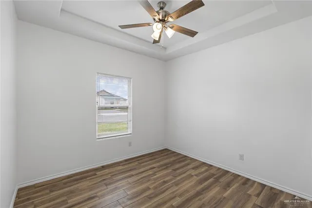 an empty room with a window and a fan