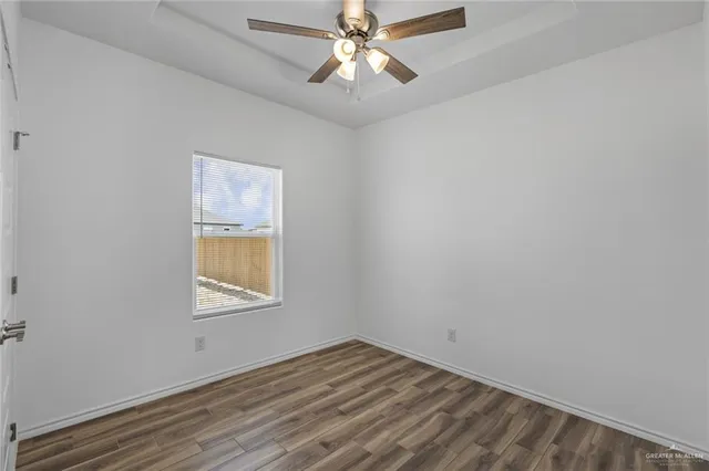 an empty room with a window and a fan