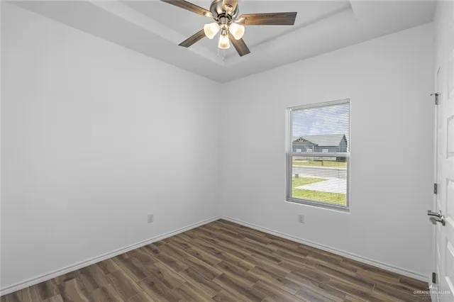 an empty room with a window and a fan