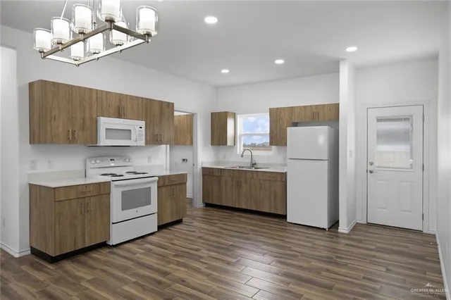 a kitchen with a sink a refrigerator a stove and cabinets