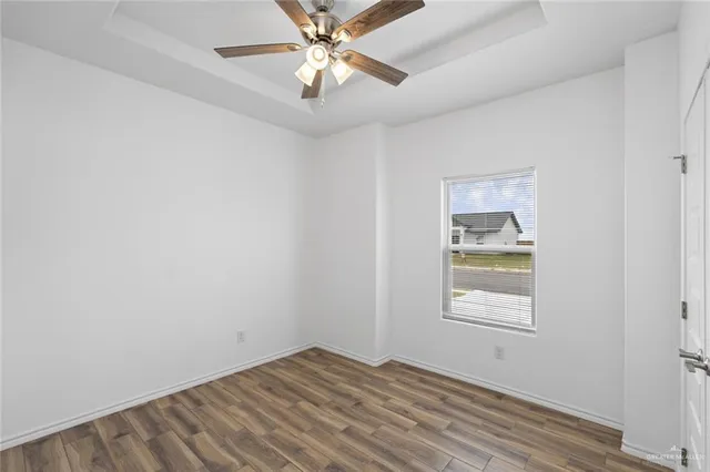 an empty room with windows and fan