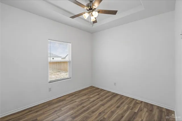 an empty room with a window and a fan