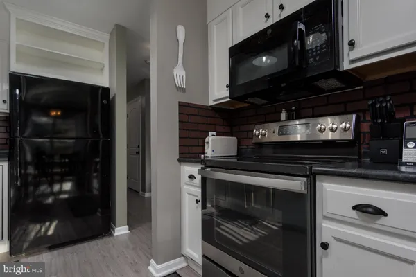 a kitchen with stainless steel appliances granite countertop a stove and a microwave