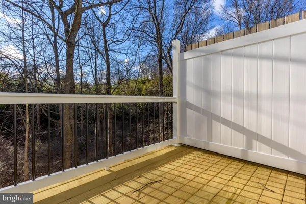 a view of a balcony with wooden floor and fence