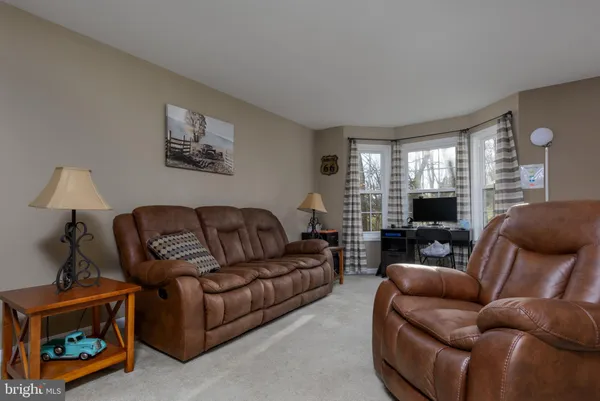 a living room with furniture a window and a flat screen tv