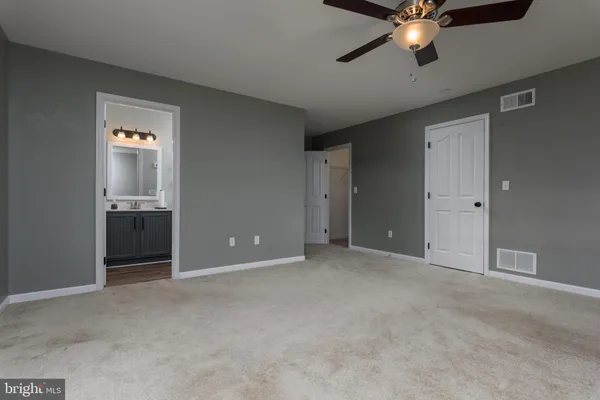 an empty room with chandelier fan