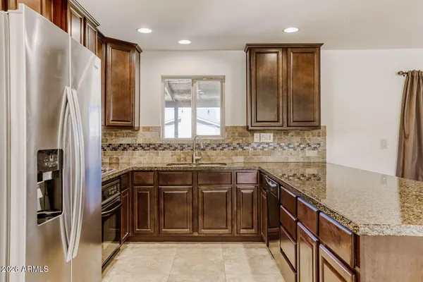 a kitchen with stainless steel appliances granite countertop a refrigerator and a sink