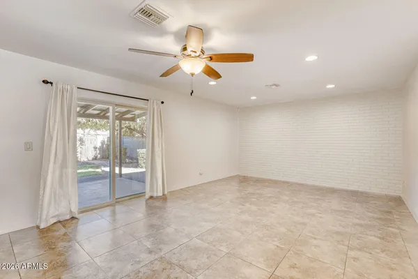 an empty room with fan and windows