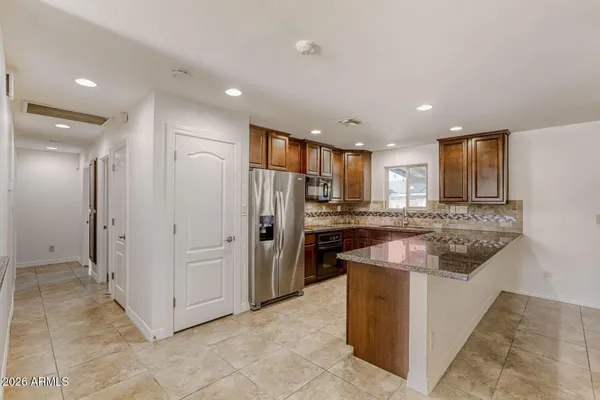a kitchen with stainless steel appliances granite countertop a refrigerator and a sink