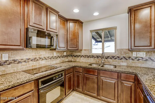 a kitchen with stainless steel appliances granite countertop a sink stove and cabinets