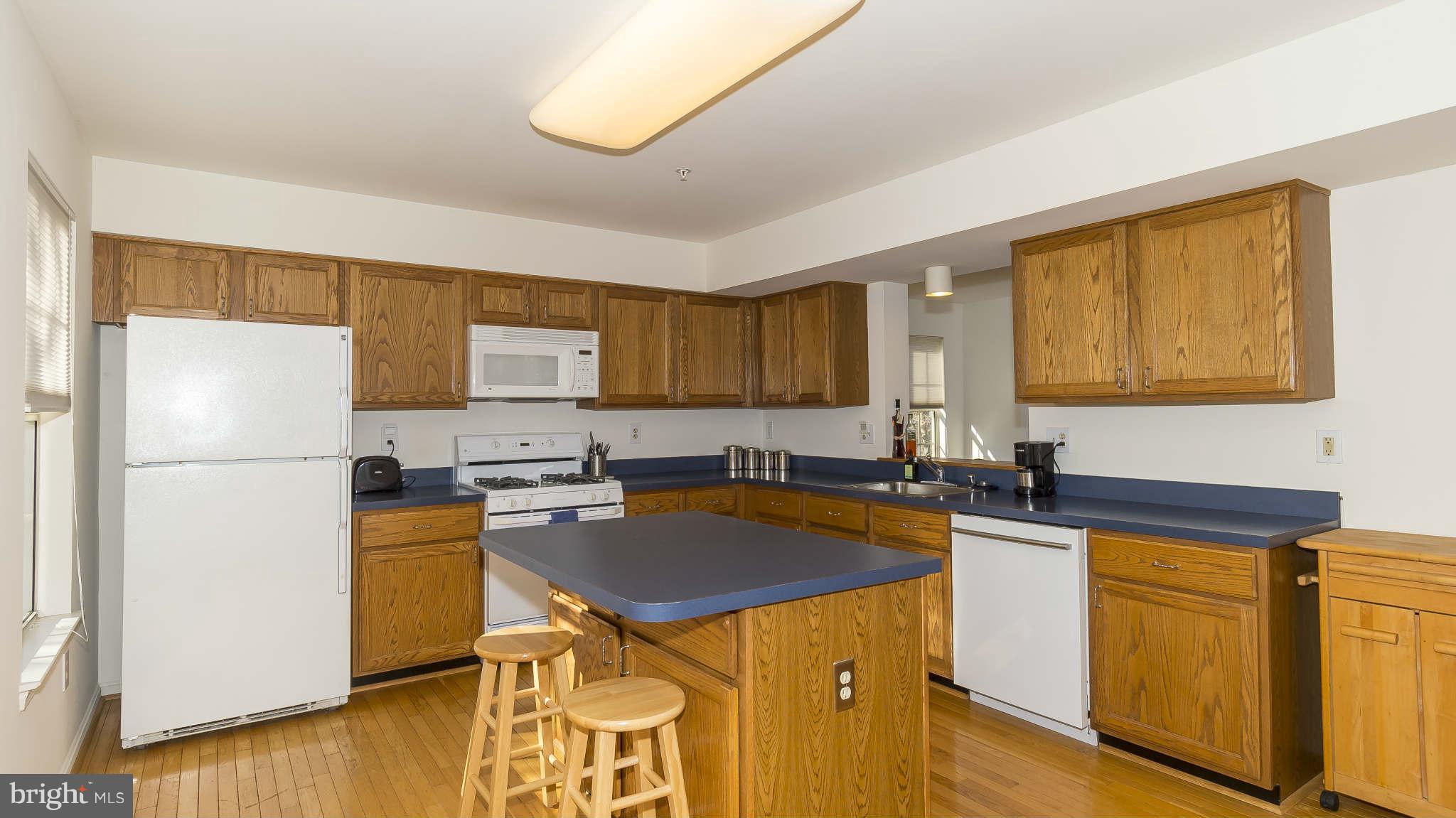 12200 Bare Bush Path Columbia, MD 21044 - Photo 11 of 30 a kitchen with a sink a stove a refrigerator cabinets and wooden floor