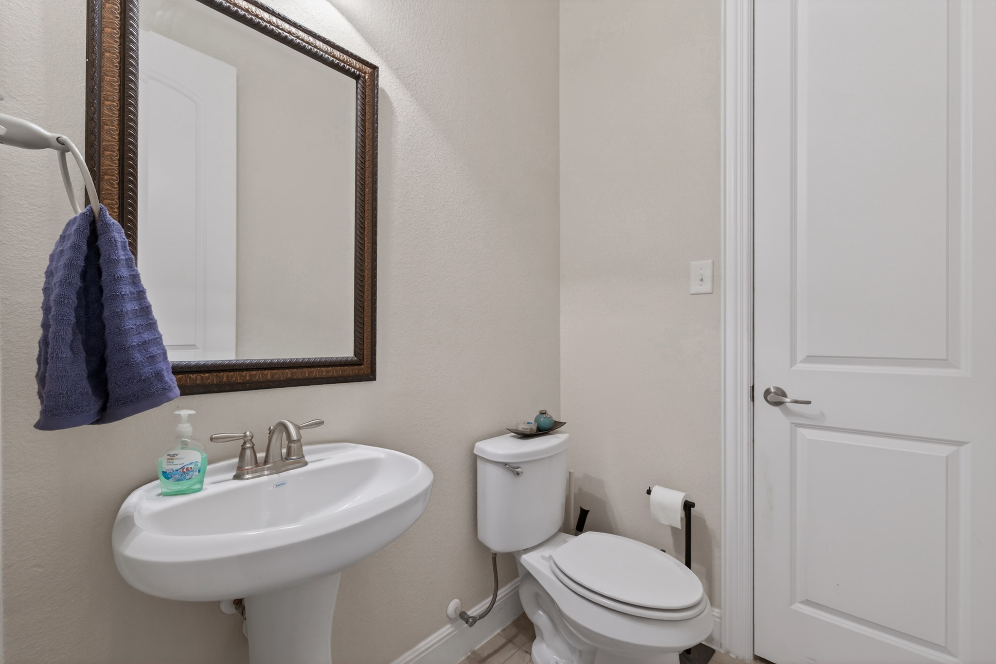 1017 Tabernash Leander, TX 78641 - Photo 33 of 38 Pedestal sink with brushed nickel faucet, framed mirror, and light neutral wall paint