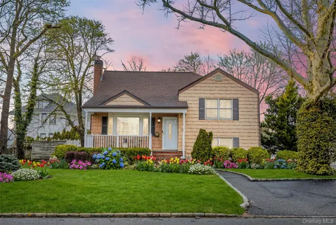 a front view of a house with a garden and pathway